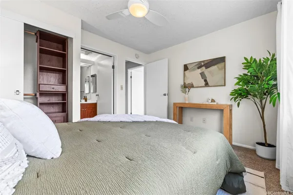 a bedroom with a bed and a potted plant