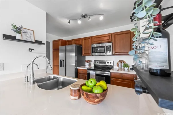 a kitchen with stainless steel appliances kitchen island granite countertop a stove and a sink