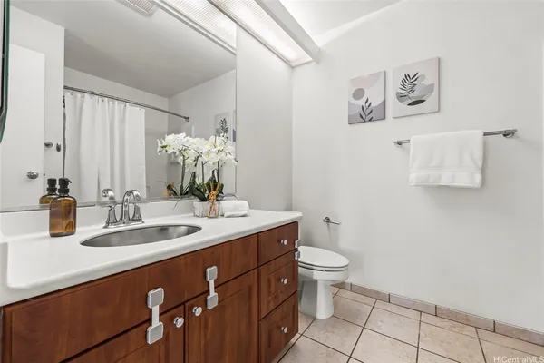 a bathroom with a granite countertop sink a toilet and a mirror