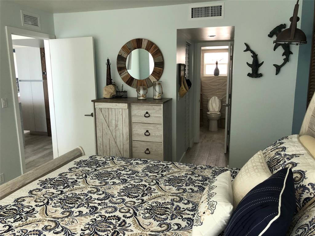 333 Northeast 21st Avenue, Unit 1216 Deerfield Beach, FL 33441 - Photo 12 of 19 a bedroom with a bed and a mirror