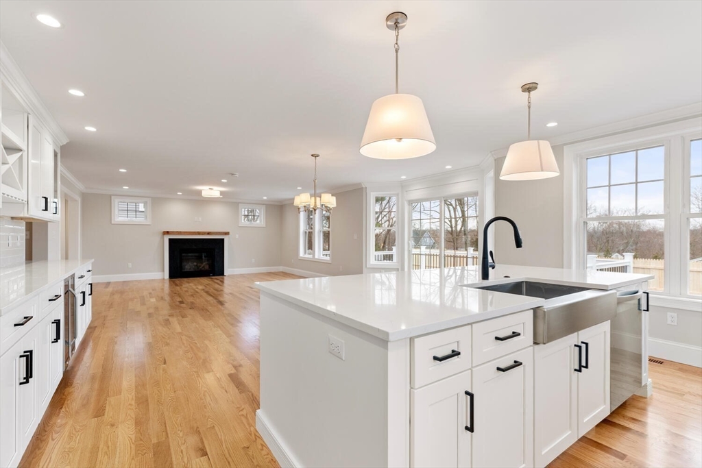 88 Hillcrest Road Waltham, MA 02451 - Photo 19 of 39 a kitchen with stainless steel appliances granite countertop a sink stove and white cabinets with wooden floor