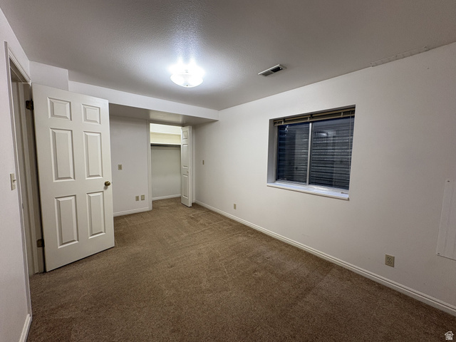 486 West 120 North Orem, UT 84057 - Photo 20 of 30 Carpeted room featuring a double-pane window with horizontal blinds, a ceiling-mounted light fixture, and two panel doors opening to a closet
