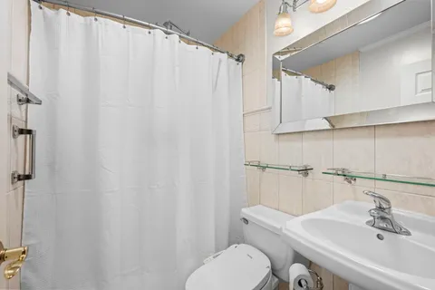 a bathroom with a sink a toilet and shower curtain