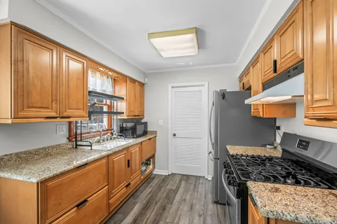 a kitchen with stainless steel appliances granite countertop a stove a sink and a refrigerator