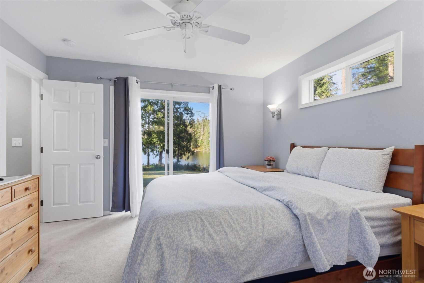 6971 Northeast Tahuya Blacksmith Road Belfair, WA 98528 - Photo 21 of 38 a bedroom with a large bed and a chandelier