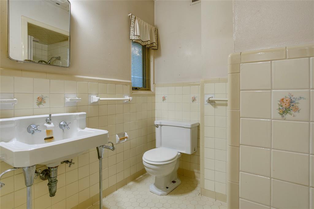 1439 Jr Drive Dallas, TX 75208 - Photo 22 of 39 a bathroom with a toilet sink and mirror