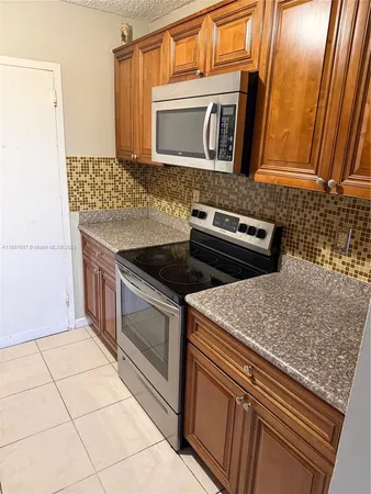 a kitchen with granite countertop a sink and a stove