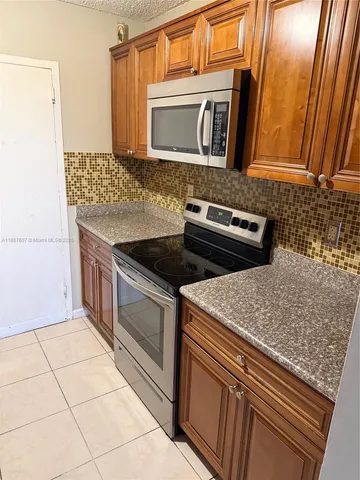 a kitchen with granite countertop a sink and a stove