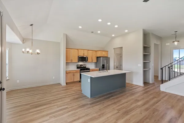 a kitchen with stainless steel appliances granite countertop a sink a stove and a refrigerator