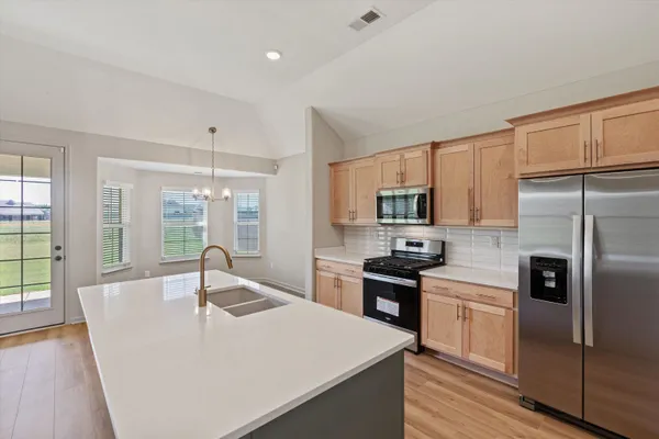 a kitchen with a sink refrigerator and wooden floor