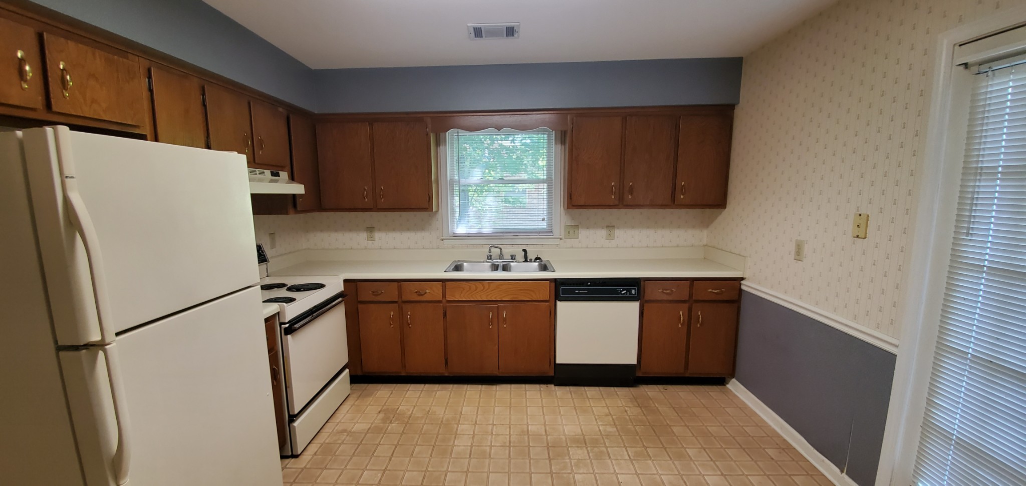 716 Kent Road Nashville, TN 37214 - Photo 14 of 15 a kitchen with granite countertop a refrigerator a sink and white cabinets