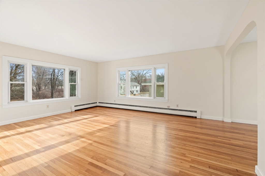10 Dulgarian Terrace, Unit 10 Chelmsford, MA 01824 - Photo 3 of 18 a view of an empty room with wooden floor and a window