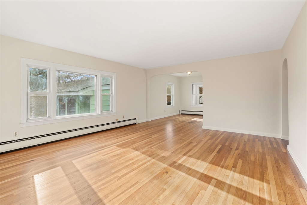 10 Dulgarian Terrace, Unit 10 Chelmsford, MA 01824 - Photo 4 of 18 a view of an empty room with wooden floor and a window