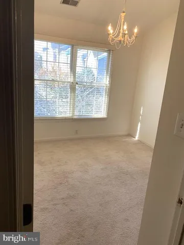 a view of a livingroom with a chandelier fan and a window