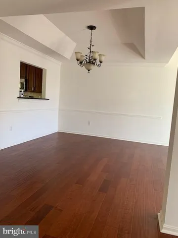 a view of a room with wooden floor and ceiling fan