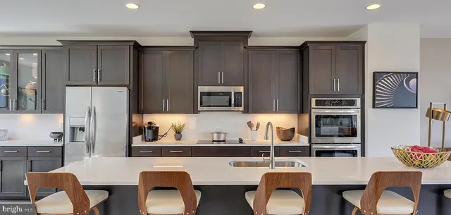 a kitchen with stainless steel appliances granite countertop a refrigerator and a stove top oven