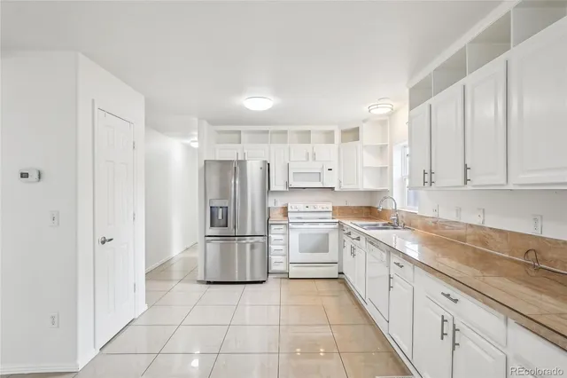 a kitchen with refrigerator and cabinets