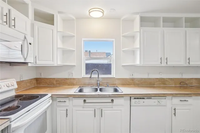 a kitchen with stainless steel appliances granite countertop a sink and cabinets with wooden floor