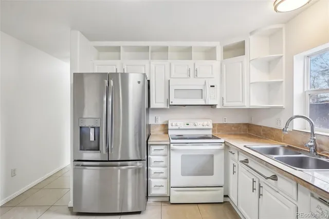 a kitchen with cabinets stainless steel appliances and sink