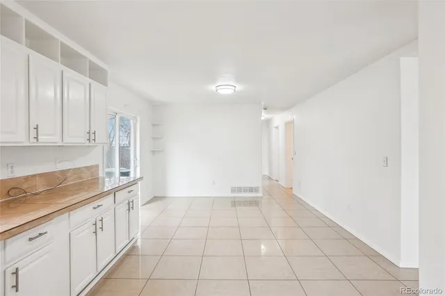 a large white kitchen with a sink and cabinets