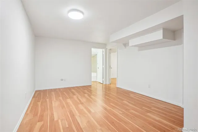 a view of empty room with wooden floor