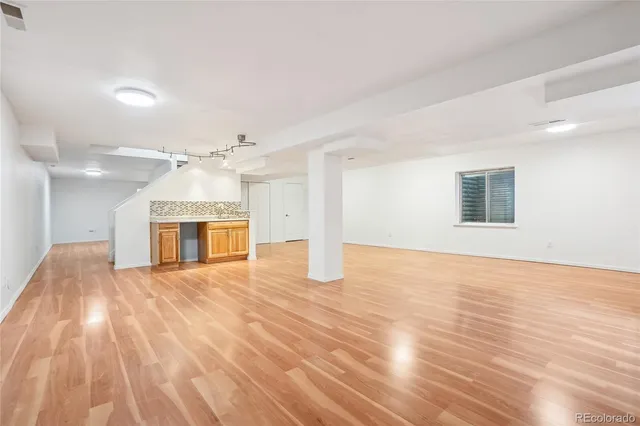 a view of empty room with wooden floor and fireplace