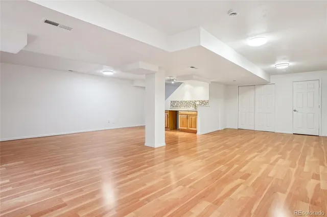 a view of empty room with wooden floor and window
