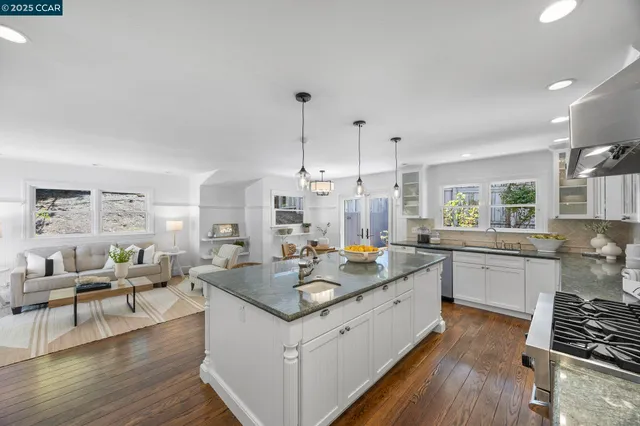 a large white kitchen with a large window and stainless steel appliances