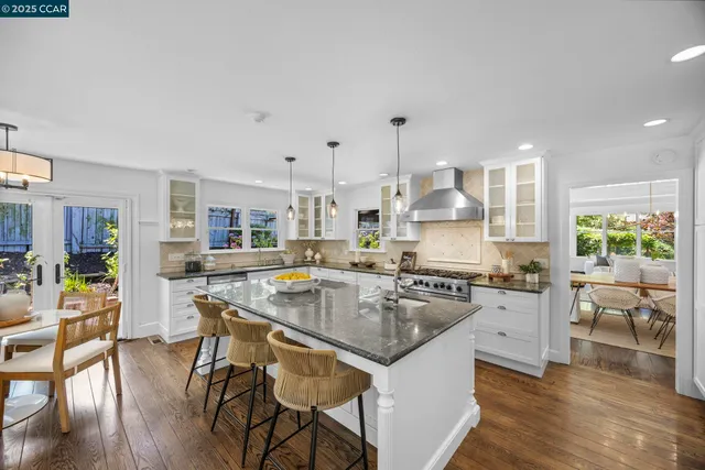 a kitchen with a table chairs stove and wooden floor