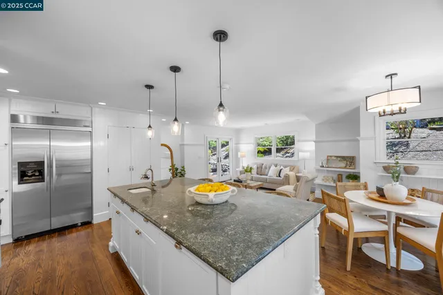 a kitchen with stainless steel appliances granite countertop a sink a stove and a wooden floors