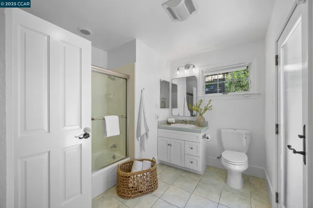 a bathroom with a granite countertop sink a toilet and a shower