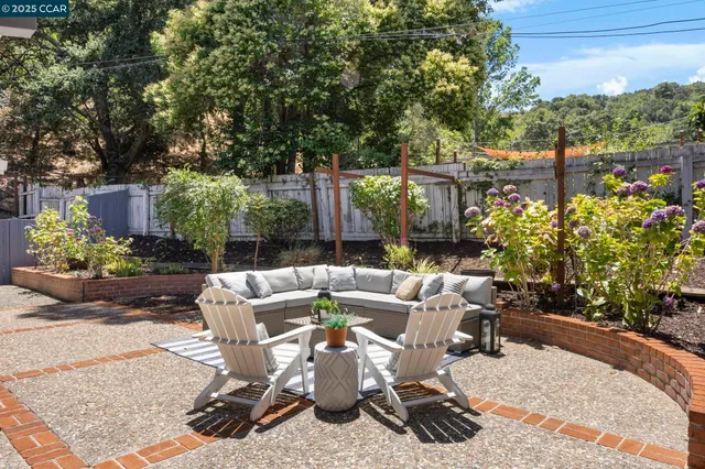 a view of a patio with couches table and chairs and potted plants