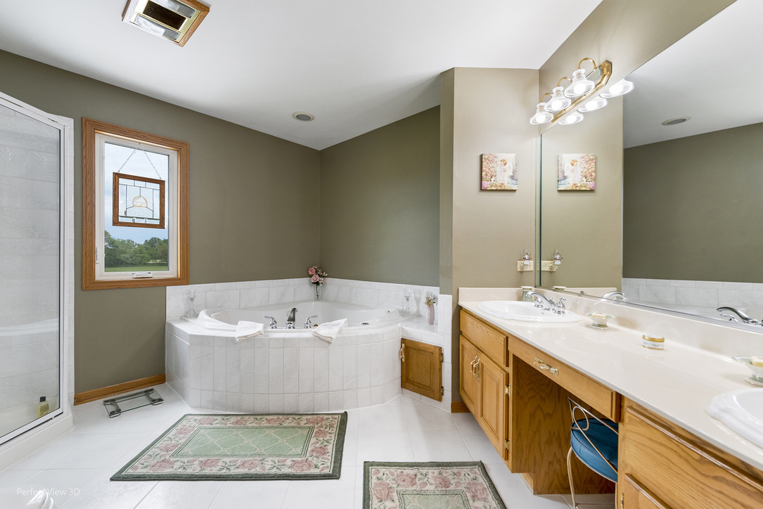 13836 West Joliet Road Manhattan, IL 60442 - Photo 18 of 25 a spacious bathroom with a sink a large mirror and a bathtub