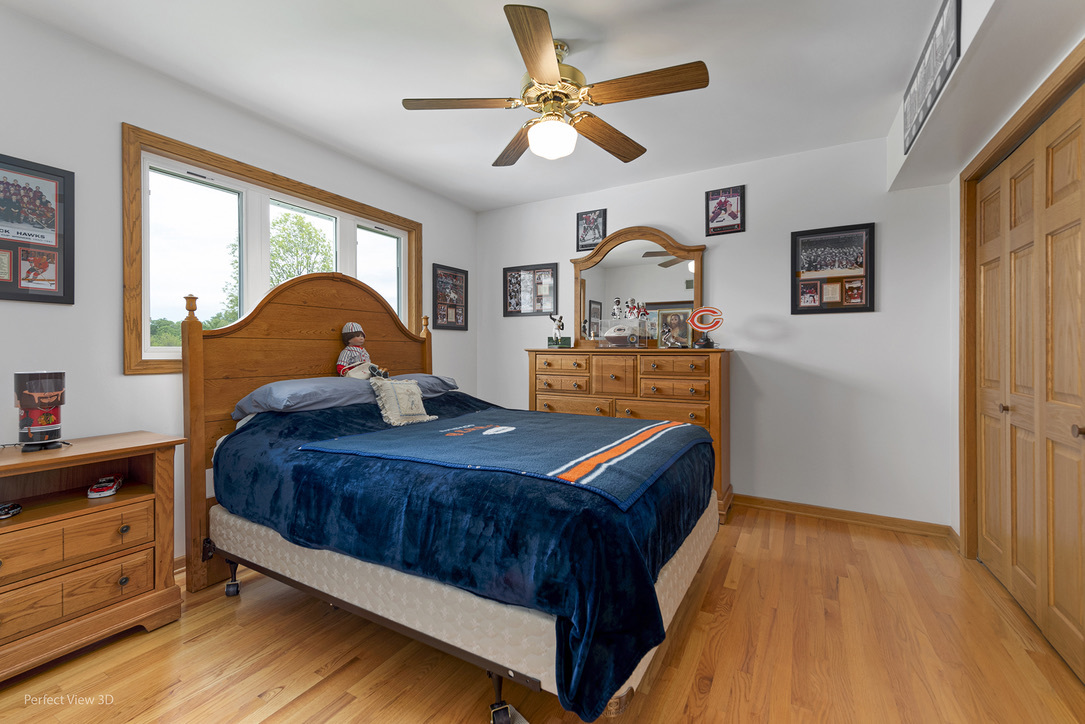 13836 West Joliet Road Manhattan, IL 60442 - Photo 21 of 25 a bed room with a bed and a chandelier