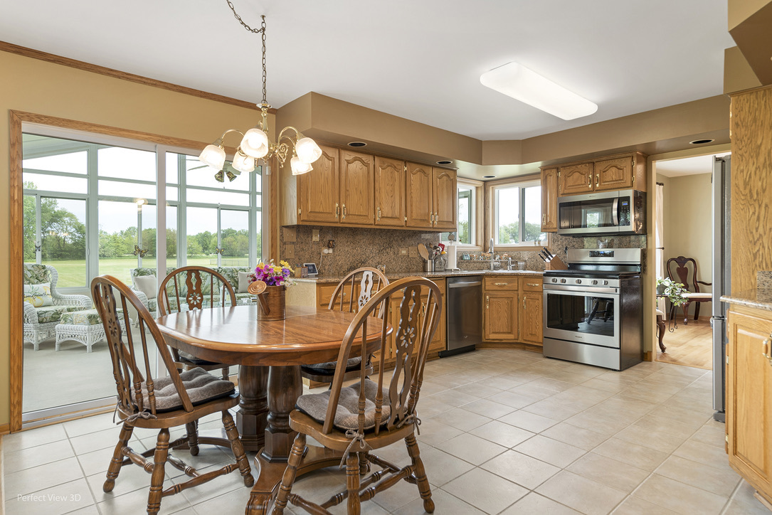 13836 West Joliet Road Manhattan, IL 60442 - Photo 7 of 25 a kitchen with stainless steel appliances granite countertop a stove a sink a microwave a dining table and chairs