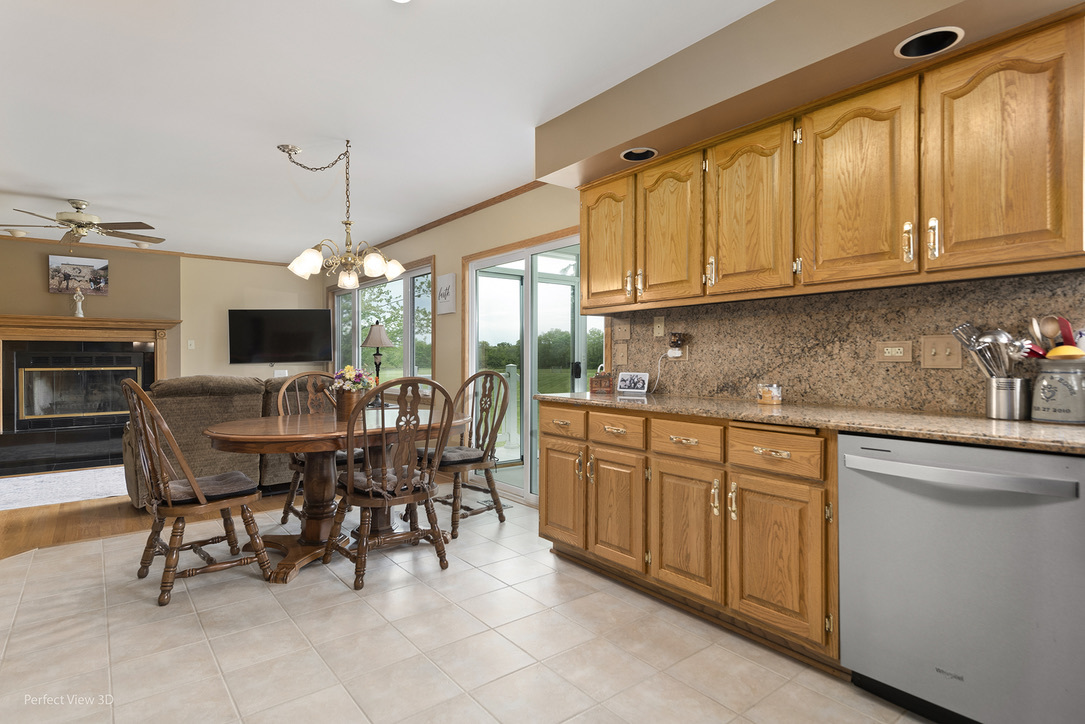 13836 West Joliet Road Manhattan, IL 60442 - Photo 10 of 25 a kitchen with stainless steel appliances granite countertop a table chairs sink and cabinets