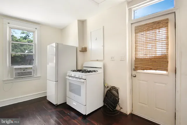 a room with a refrigerator and a window