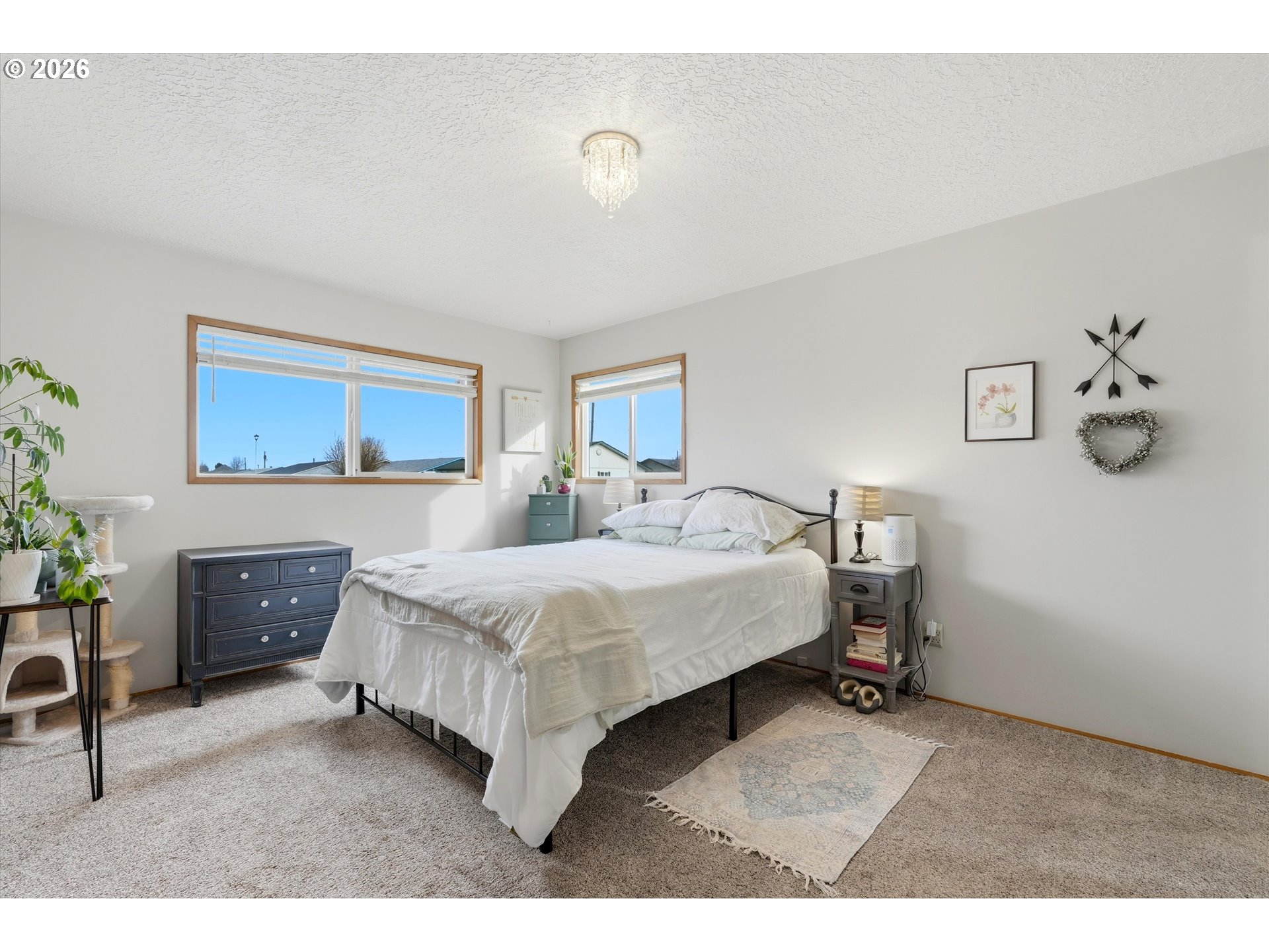 1841 Umpqua Road Woodburn, OR 97071 - Photo 33 of 41 a spacious bedroom with a bed a couch and paintings on the wall