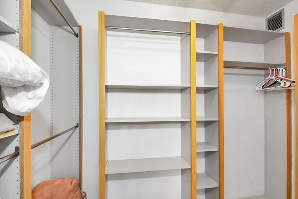 a view of walk in closet with empty racks