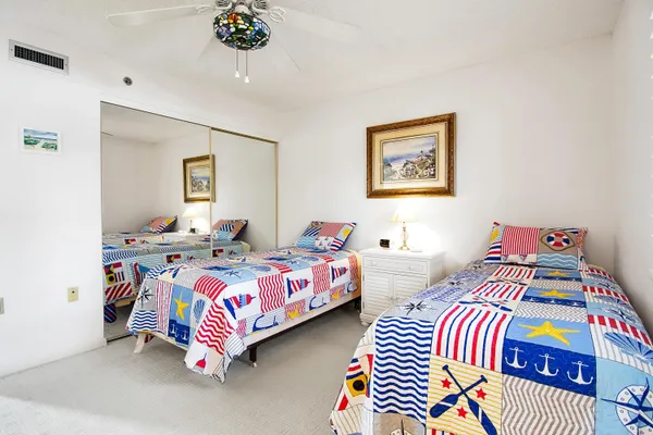 a bedroom with two beds and painting on the wall