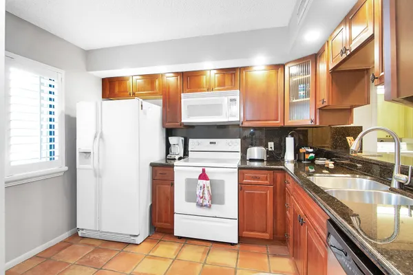 a kitchen with stainless steel appliances granite countertop a sink and a refrigerator