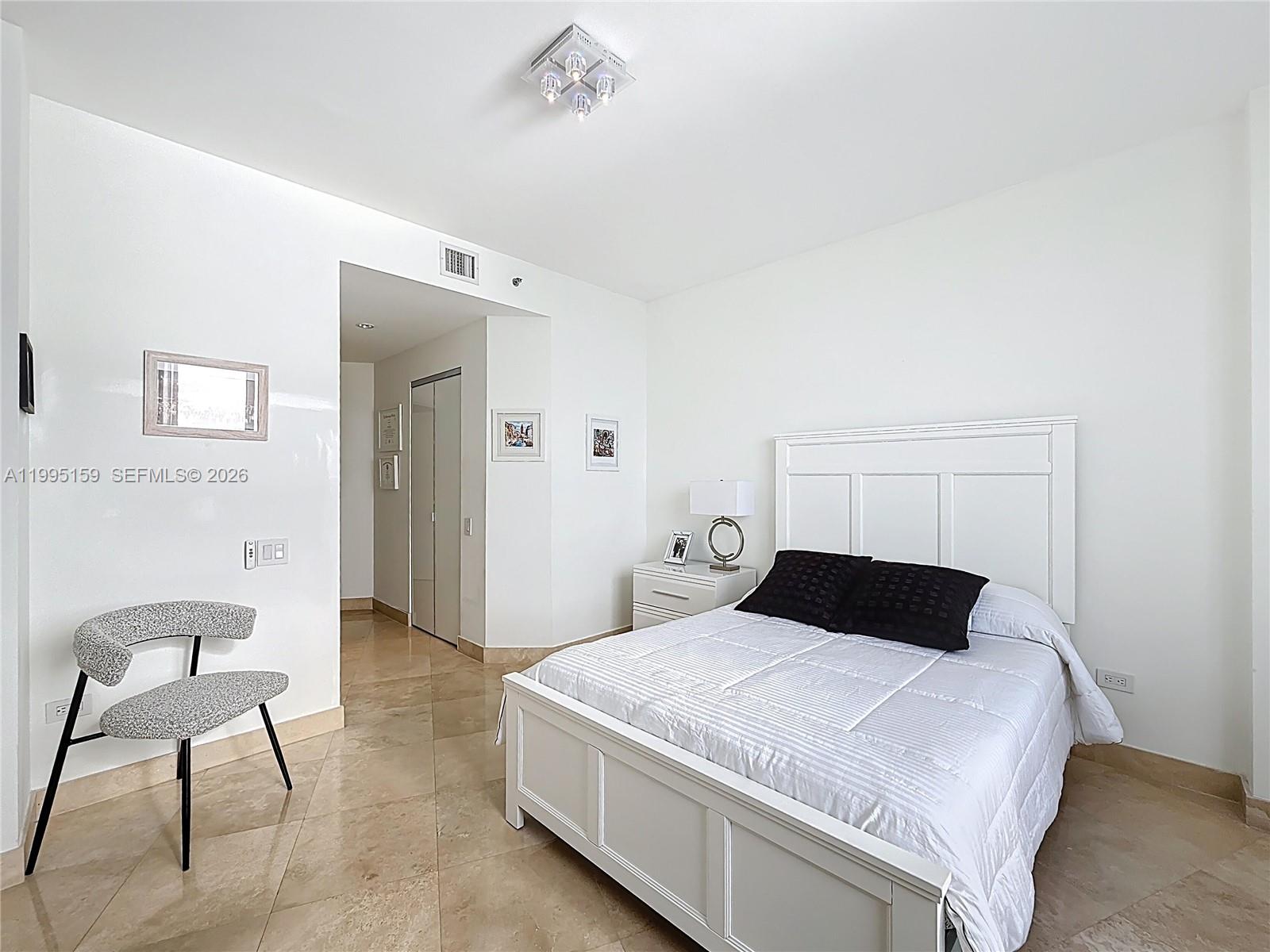 808 Brickell Key Drive, Unit 2002 Miami, FL 33131 - Photo 19 of 42 a bedroom with a bed and chair