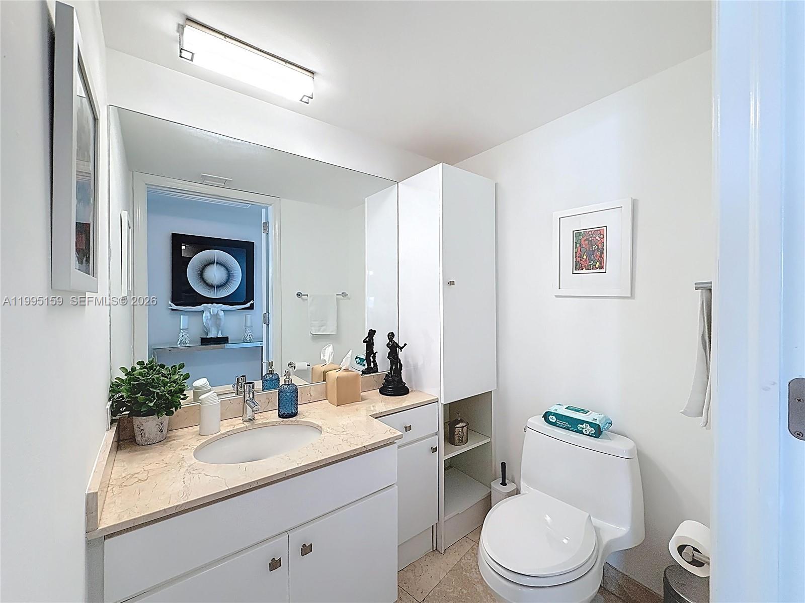 808 Brickell Key Drive, Unit 2002 Miami, FL 33131 - Photo 21 of 42 a bathroom with a toilet a sink and mirror