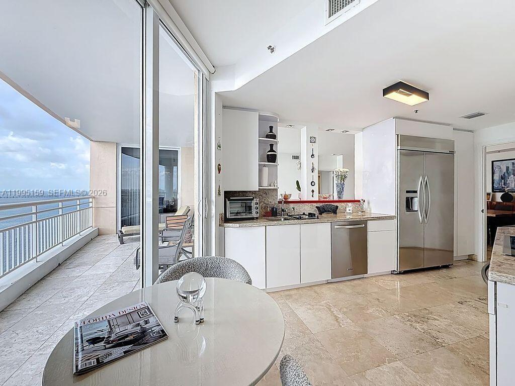 808 Brickell Key Drive, Unit 2002 Miami, FL 33131 - Photo 22 of 42 a large white kitchen with kitchen island a sink a stove and a refrigerator