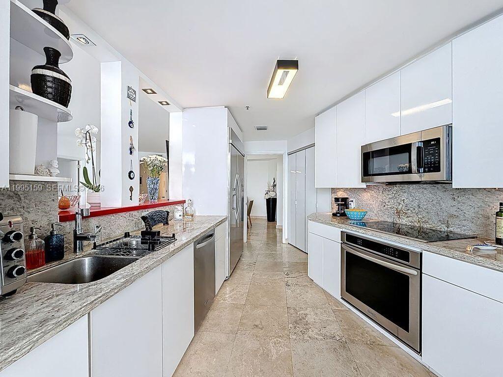 808 Brickell Key Drive, Unit 2002 Miami, FL 33131 - Photo 24 of 42 a large kitchen with stainless steel appliances granite countertop a stove and a sink