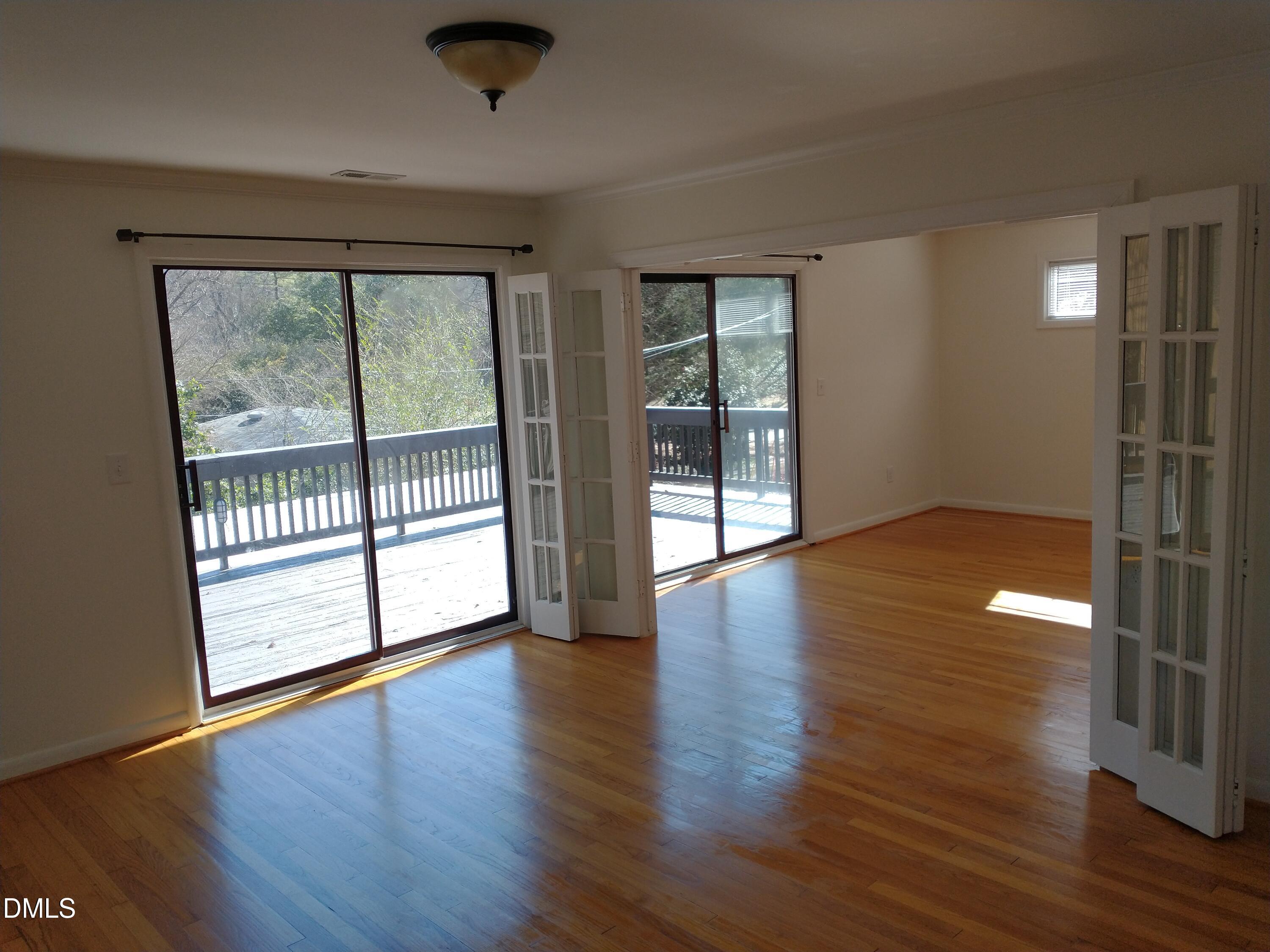 1302 Lorimer Road Raleigh, NC 27606 - Photo 11 of 23 an empty room with wooden floor and windows