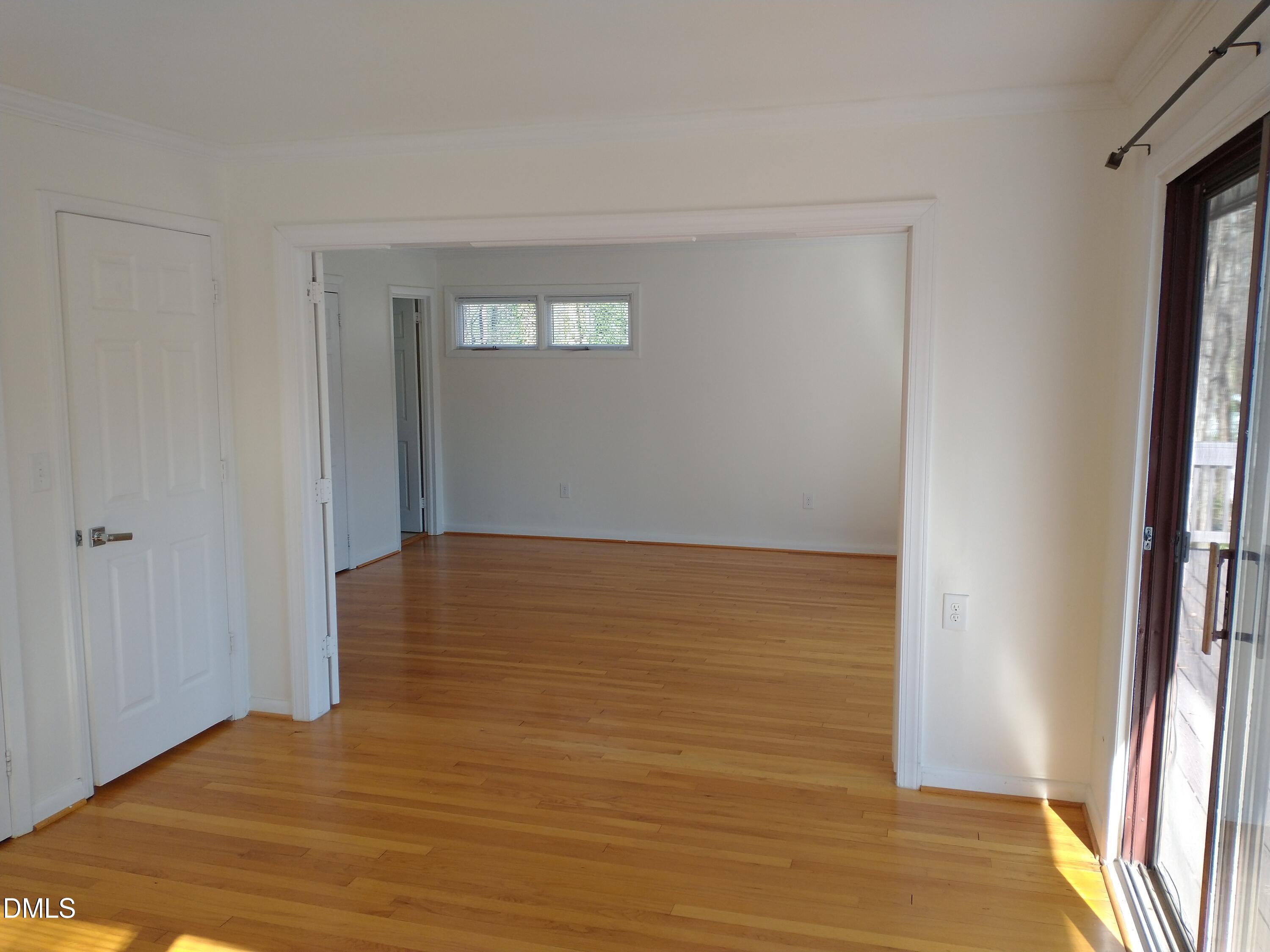 1302 Lorimer Road Raleigh, NC 27606 - Photo 13 of 23 a view of an empty room with wooden floor and a window