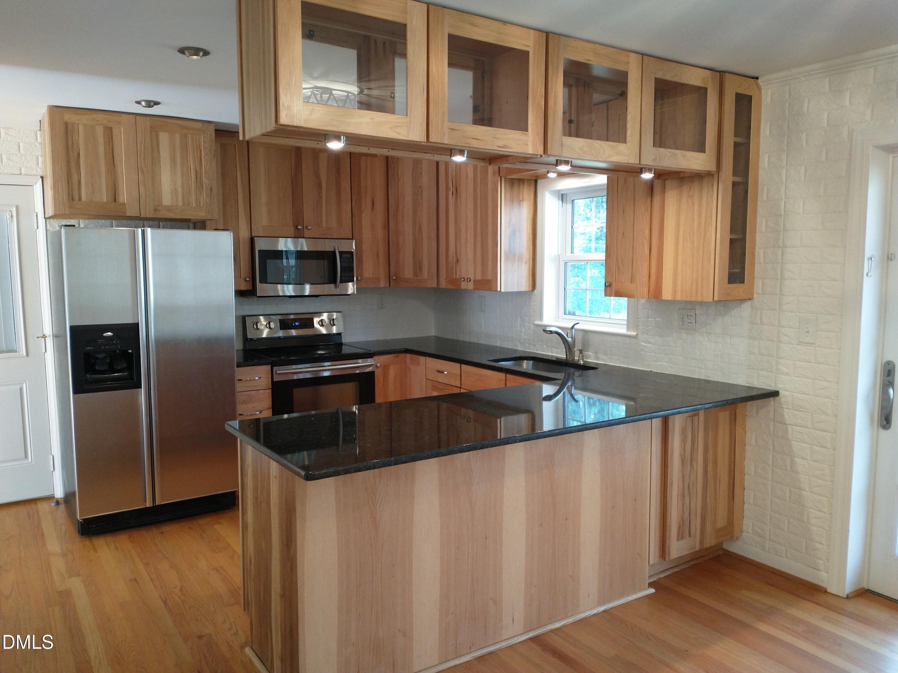1302 Lorimer Road Raleigh, NC 27606 - Photo 5 of 23 a kitchen with stainless steel appliances granite countertop a sink a stove and a refrigerator