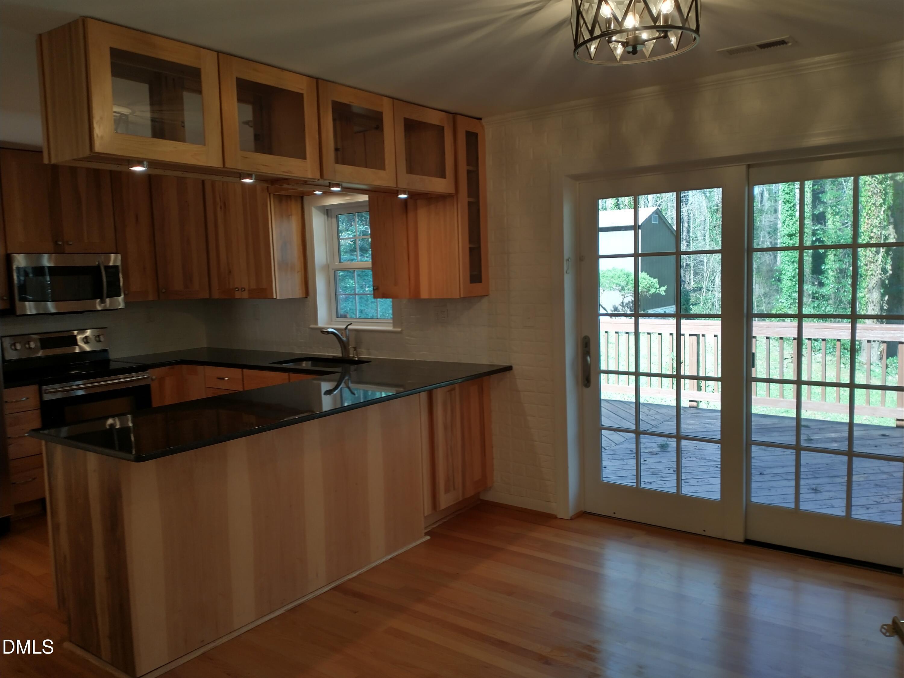1302 Lorimer Road Raleigh, NC 27606 - Photo 6 of 23 a kitchen with stainless steel appliances granite countertop a sink and a stove next to a large window