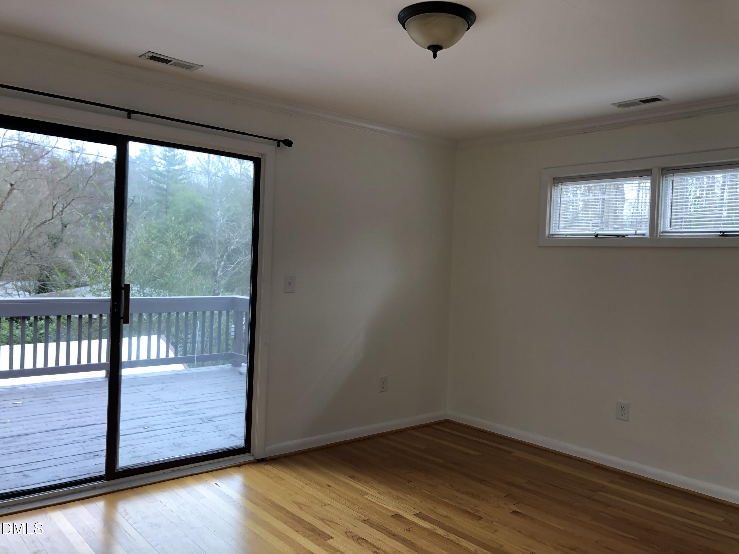 1302 Lorimer Road Raleigh, NC 27606 - Photo 7 of 23 an empty room with wooden floor and windows